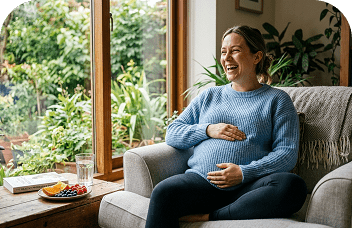 Pregnant woman relaxing on sofa smiling with healthy snacks