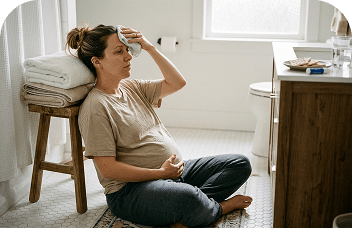 Pregnant woman experiencing morning sickness in the bathroom